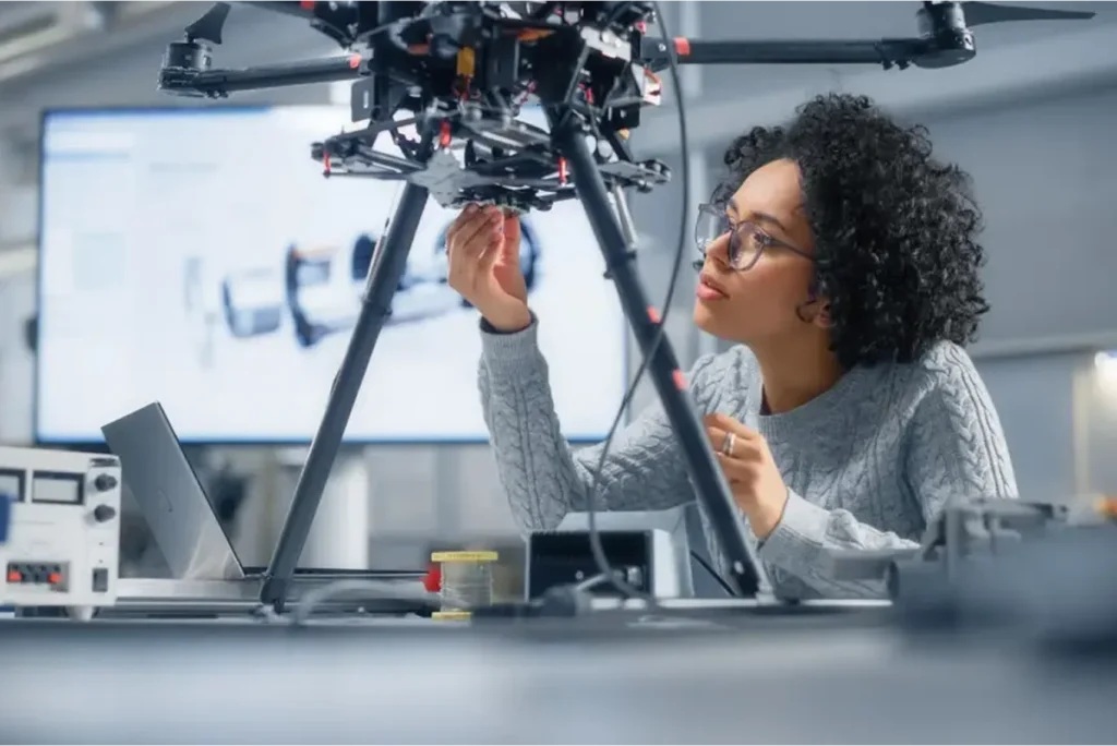 A woman works in a lab on a piece of machinery